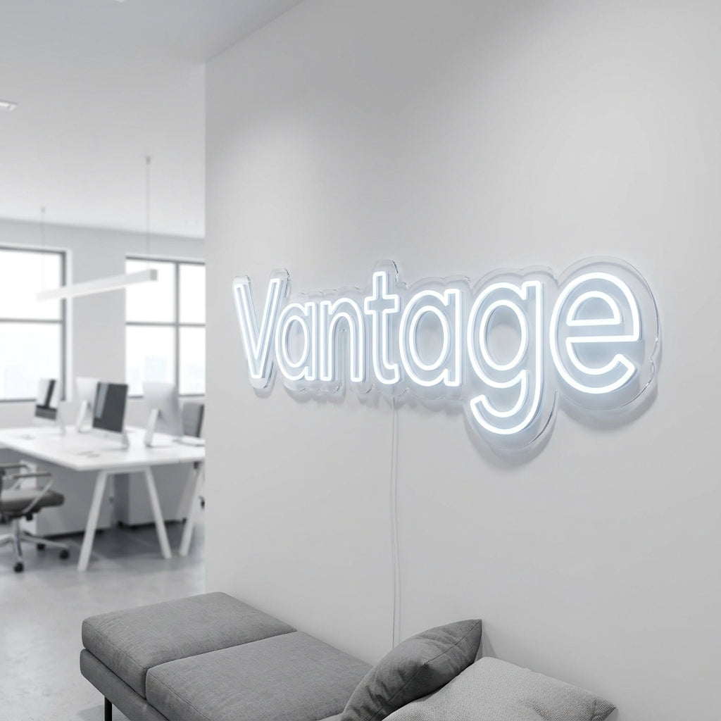 Kühlweißes LED-Neon-Logo „Vantage“ an einer Bürowand im Großraumbüro – Neon Atelier