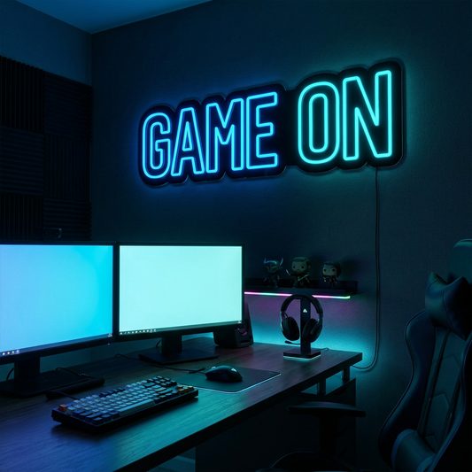 Elektroblaues LED-Neonschild „GAME ON“ über einem Gaming-Setup mit RGB-Beleuchtung – Neon Atelier