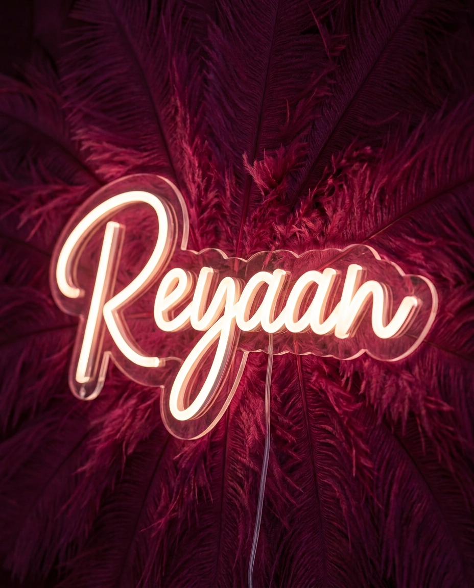 LED-Neonschild „Reyaan“ vor Federn-Wanddeko im Kinderzimmer – Neon Atelier