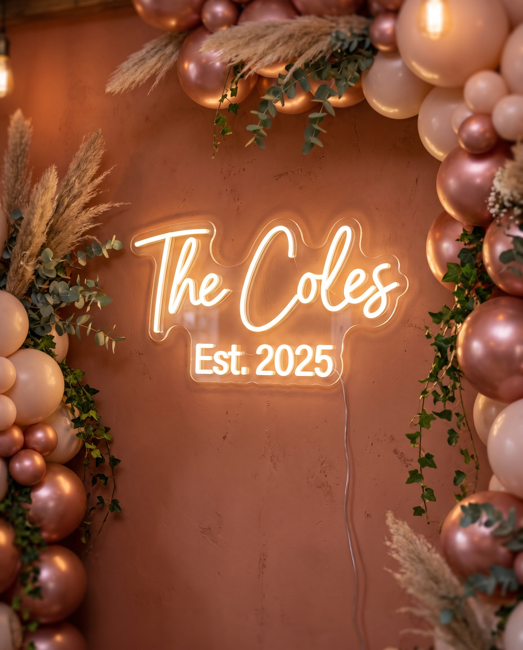 LED-Neonschild „The Coles Est. 2025“ zwischen Luftballons bei der Hochzeit – Neon Atelier