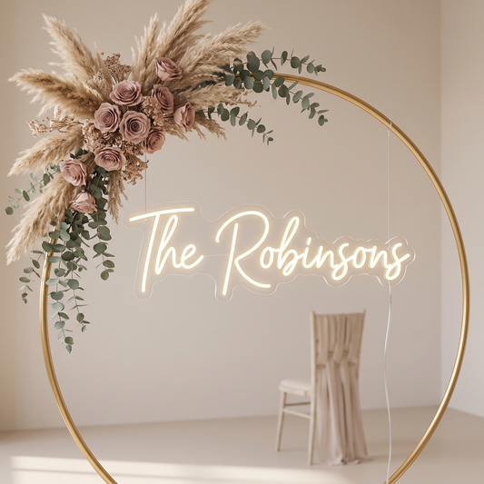 LED-Neonschild „The Robinsons“ freistehend an einem Rundbogen bei der Hochzeit – Neon Atelier