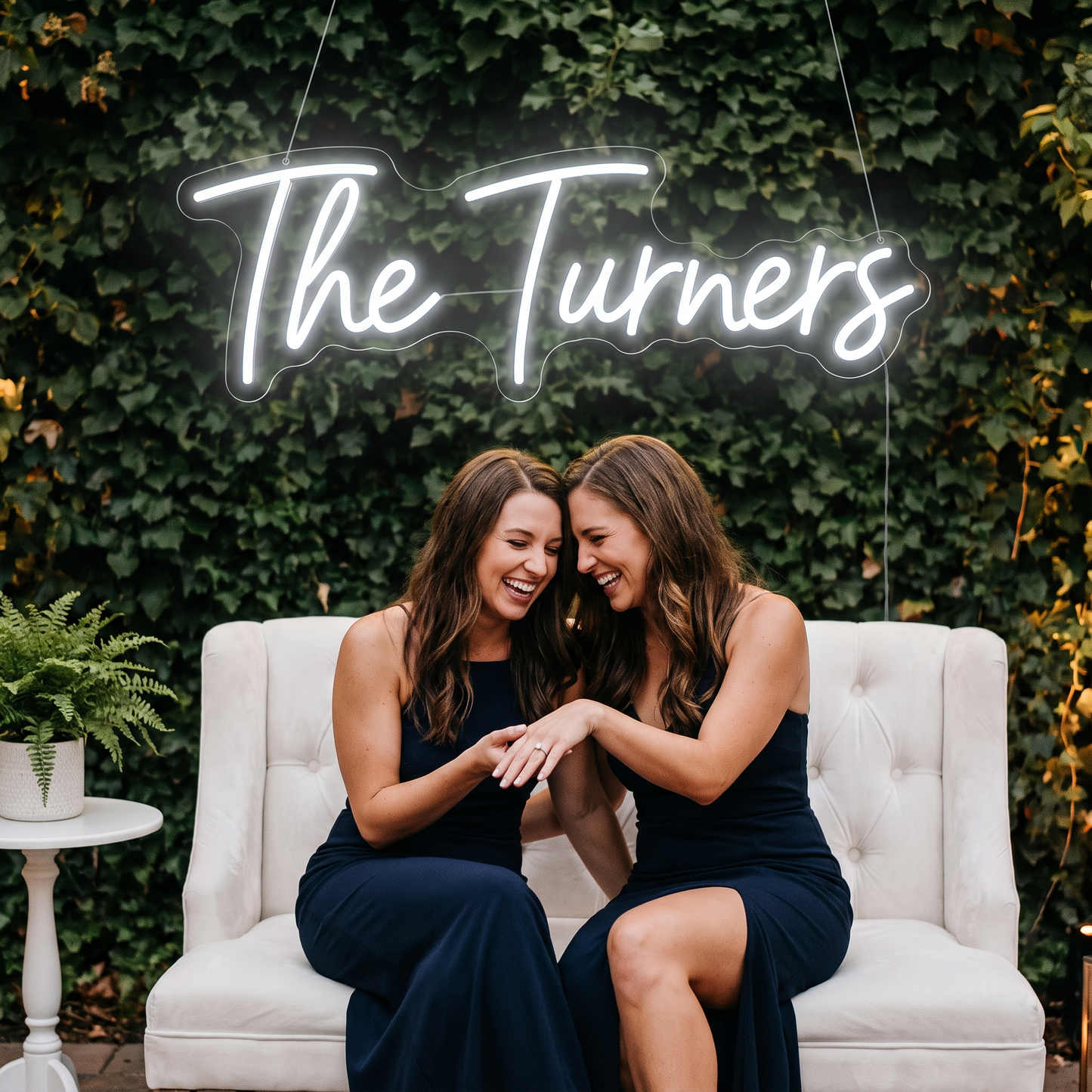 LED-Neonschild „The Turners“ über einer Sitzbank mit Freundinnen bei der Hochzeit – Neon Atelier